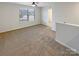 Upstairs loft area featuring neutral carpet, a ceiling fan, and a window for natural light at 133 Sequoia St, Mooresville, NC 28117