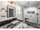 Modern bathroom with a glass-enclosed shower featuring marble tile and a black vanity with a black granite countertop at 1331 14Th Ne St, Hickory, NC 28601