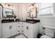Bright bathroom with dual sinks, black granite countertops, and white cabinets at 1331 14Th Ne St, Hickory, NC 28601