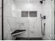 Modern shower with marble tile surround, rainfall showerhead, and a black granite corner seat at 1331 14Th Ne St, Hickory, NC 28601