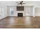 Spacious living room with wood-look floors and fireplace, flooded with natural light at 13424 Kibworth Ln, Charlotte, NC 28273