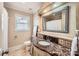 Bathroom with marble countertop and decorative mirror, featuring a toilet and window for natural light at 1409 Cortland W Rd, Charlotte, NC 28209