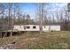 Cozy single-story home featuring a long layout and wooded surroundings during the daytime at 144 Cherokee Ln, New London, NC 28127