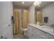 Well-lit bathroom with double vanity, framed mirror, shower with decorative curtain and tiled floors at 149 High Rock Ct # 02, Statesville, NC 28677