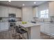 Bright kitchen features white cabinetry, stainless steel appliances, granite countertops, and a center island with seating at 149 High Rock Ct # 02, Statesville, NC 28677