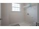 Compact laundry area with a window, shelf, and tile flooring at 149 High Rock Ct # 02, Statesville, NC 28677