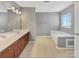Spacious bathroom featuring double vanity sinks, a soaking tub, and separate shower at 15120 Callow Forest Dr, Charlotte, NC 28273