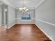 Bright dining room featuring hardwood floors, large window, chandelier, and neutral gray walls at 15120 Callow Forest Dr, Charlotte, NC 28273