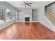 Bright living room with fireplace, built-in shelves, hardwood floors, and staircase at 15120 Callow Forest Dr, Charlotte, NC 28273