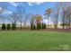 Expansive backyard with lush lawn and mature trees offers a serene and private outdoor space at 17429 Staysail Ct, Cornelius, NC 28031