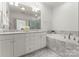 Luxurious bathroom with marble floors, double vanity, soaking tub, and glass enclosed shower at 17429 Staysail Ct, Cornelius, NC 28031