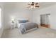 Bright bedroom featuring a ceiling fan, ensuite bathroom access, and plush carpeting at 17429 Staysail Ct, Cornelius, NC 28031