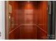 Interior view of home elevator with rich wood paneling and brass fixtures at 17429 Staysail Ct, Cornelius, NC 28031