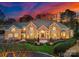 Stunning brick home showcasing manicured landscaping and a grand entrance illuminated by elegant outdoor lighting at 17429 Staysail Ct, Cornelius, NC 28031