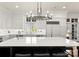 A spacious kitchen with white cabinets, stainless steel appliances, a marble island, and a modern chandelier at 17429 Staysail Ct, Cornelius, NC 28031
