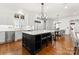 Open kitchen featuring a large island with seating, stainless steel appliances, and a view into the dining area at 17429 Staysail Ct, Cornelius, NC 28031