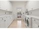 Bright laundry room with ample white cabinets and counter space, plus modern washer and dryer at 17429 Staysail Ct, Cornelius, NC 28031
