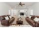 Spacious living room featuring custom built-ins, a ceiling fan, and leather sofas at 17429 Staysail Ct, Cornelius, NC 28031