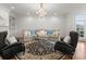 Well-lit living room featuring a comfortable sofa, armchairs, and a decorative chandelier at 17429 Staysail Ct, Cornelius, NC 28031
