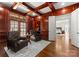 Rich wood-paneled office with coffered ceiling, hardwood floors, and leather chairs at 17429 Staysail Ct, Cornelius, NC 28031