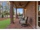 Covered patio with brick columns offers a cozy outdoor seating area and ceiling fan at 17429 Staysail Ct, Cornelius, NC 28031