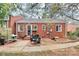 Backyard patio with a seating area, surrounded by brickwork and mature trees at 1817 Jameston Dr, Charlotte, NC 28209