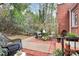 Backyard patio featuring a seating area with a small table and mature trees and plantings at 1817 Jameston Dr, Charlotte, NC 28209