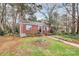 Charming red brick home with walkway and a beautifully landscaped yard featuring a white bench and blooming flowers at 1817 Jameston Dr, Charlotte, NC 28209