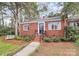 Charming red brick home with black door, white trim, and landscaped front yard and brick walkway at 1817 Jameston Dr, Charlotte, NC 28209