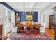 A formal dining room featuring a coffered ceiling, blue accent wall, and a large chandelier, perfect for entertaining at 19118 Betty Stough Rd, Cornelius, NC 28031