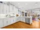 An open concept kitchen with white cabinetry, stainless steel appliances, and a lovely breakfast nook with view at 19118 Betty Stough Rd, Cornelius, NC 28031