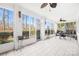 Bright sunroom with white brick walls, tile floors, and large windows offering scenic views at 19118 Betty Stough Rd, Cornelius, NC 28031