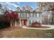 Two-story home featuring dormer windows and a red front door, surrounded by landscaped yard and trees at 2101 Darian Way, Waxhaw, NC 28173