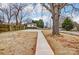 Spacious backyard showcasing a large tree, concrete path, partial fencing, and ample space for outdoor activities at 2313 N Main St, Kannapolis, NC 28081