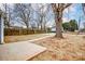 The open backyard offers a versatile space with a large tree, concrete slab, and fencing at 2313 N Main St, Kannapolis, NC 28081