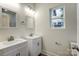 Bathroom featuring double sink vanity, white cabinets, and a bright window at 2313 N Main St, Kannapolis, NC 28081
