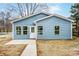 Charming blue home showcasing a well-manicured lawn and a welcoming entryway with decorative glass front door at 2313 N Main St, Kannapolis, NC 28081