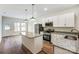 Well-appointed kitchen with an island, white cabinetry, granite counters, and stainless steel appliances at 2313 N Main St, Kannapolis, NC 28081