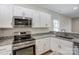 A well-equipped kitchen featuring granite countertops, stainless steel appliances, and white cabinets at 2313 N Main St, Kannapolis, NC 28081