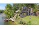 Lakeside house with private dock and multiple decks surrounded by lush greenery at 27056 Catamaran Dr, Tega Cay, SC 29708