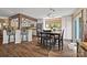 Dining area with a view to the kitchen, wood floors, and natural light from a large window at 27056 Catamaran Dr, Tega Cay, SC 29708