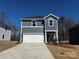 Charming two-story home with a grey exterior, white garage door, and a well-manicured lawn on a sunny day at 309 Alden Ct, Shelby, NC 28152