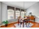 Light-filled dining room features wood floors, a modern chandelier, and large windows with custom valances at 3350 Keady Mill Loop, Kannapolis, NC 28081