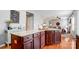 Kitchen island with granite countertop, dark cabinets, and wood floors is open to the living room at 3350 Keady Mill Loop, Kannapolis, NC 28081