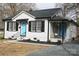 Charming home with a blue front door, dark shutters, and a well-manicured front yard at 407 E Talleyrand St, Monroe, NC 28112