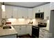 Well-lit kitchen with stylish white cabinetry, stainless steel microwave, and modern subway tile backsplash at 407 E Talleyrand St, Monroe, NC 28112