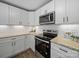 Updated kitchen boasts white cabinets, granite countertops, and stainless steel appliances at 407 E Talleyrand St, Monroe, NC 28112