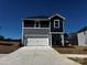 Two-story home featuring gray siding, a white garage door, and a well-maintained concrete driveway at 410 Luna Ln, Shelby, NC 28152