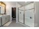 Modern bathroom showcasing a tiled shower with a glass door, gray vanity, and tiled floors at 4660 Ardmore Ln, Harrisburg, NC 28075