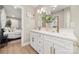 Bright bathroom with double vanity sinks, gold faucet, and a view to the bedroom and hallway at 4820 Valley Stream Rd, Charlotte, NC 28209